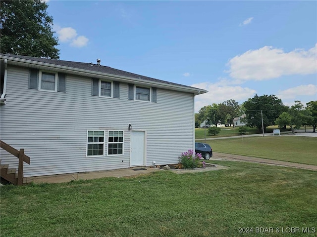 rear view of house featuring a lawn