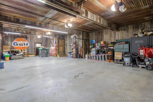 garage with a garage door opener and wooden walls