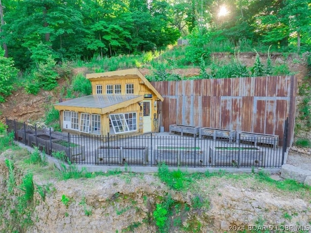 rear view of property with an outdoor structure