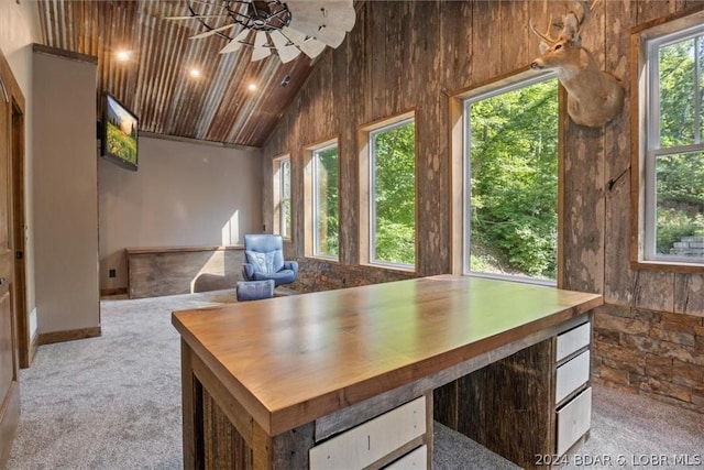 unfurnished office featuring high vaulted ceiling, a chandelier, and light carpet