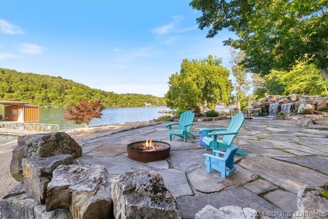 view of patio featuring a water view and an outdoor fire pit