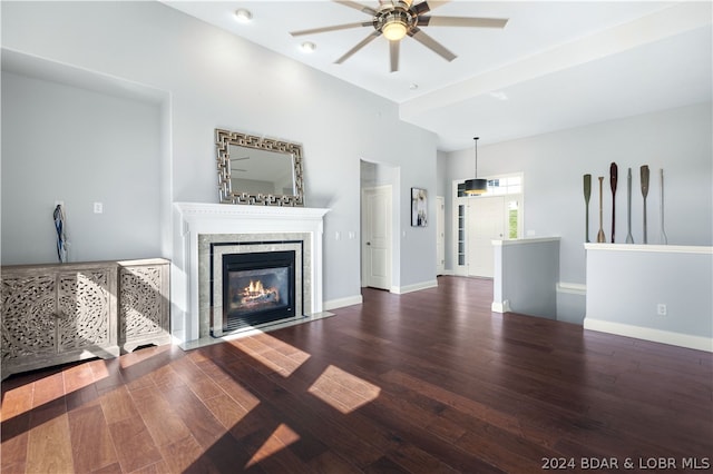 unfurnished living room featuring dark hardwood / wood-style floors, ceiling fan, and a fireplace