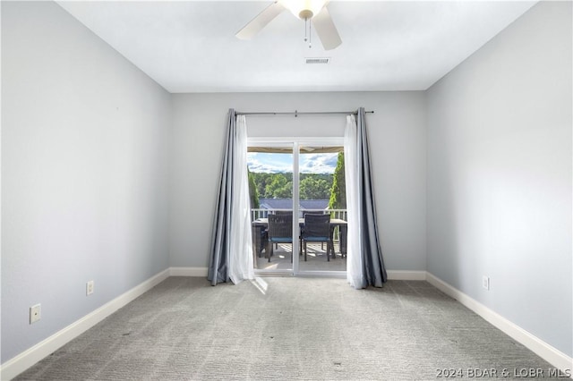 carpeted spare room featuring ceiling fan