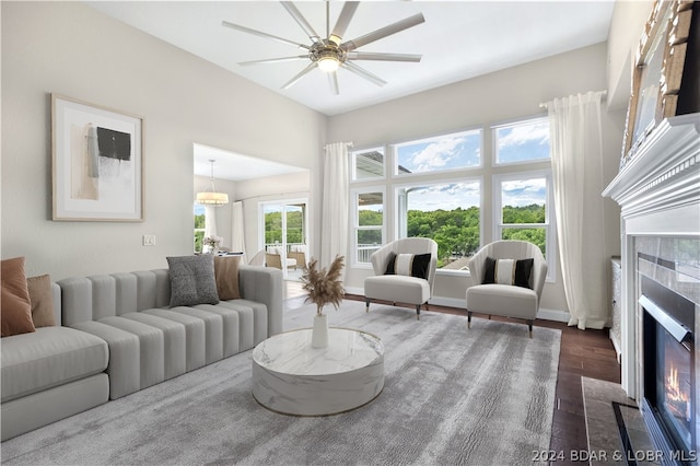 living room featuring wood-type flooring, ceiling fan, and a premium fireplace