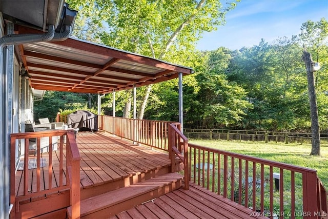 deck featuring grilling area and a lawn