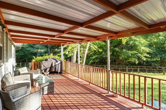 deck with an outdoor living space, a lawn, and a grill