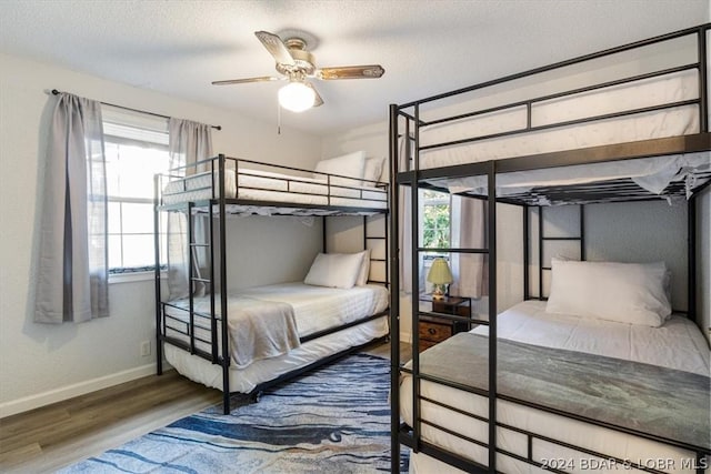 bedroom featuring wood-type flooring, a textured ceiling, and ceiling fan