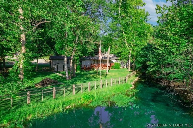 view of yard with a shed and a water view