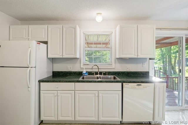 kitchen with white appliances, white cabinets, sink, and a textured ceiling