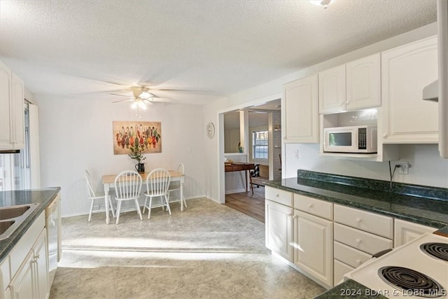 1465 Easy St, Osage Beach, MO 65065 - kitchen with white appliances, dark countertops, a textured ceiling, white cabinetry, and ceiling fan