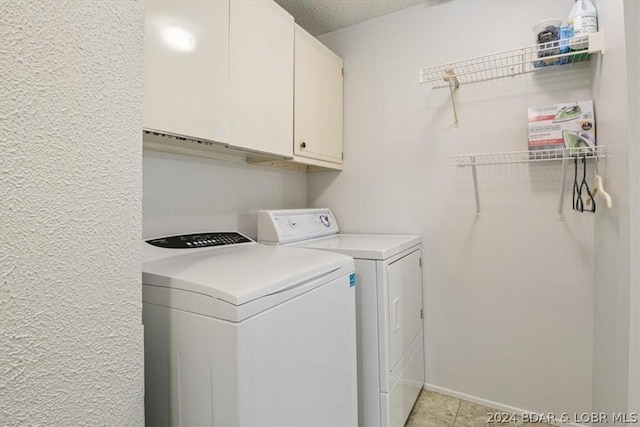 1465 Easy St, Osage Beach, MO 65065 - laundry room with washer and clothes dryer, cabinet space, and a textured ceiling
