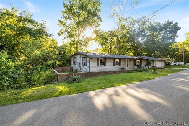 ranch-style home featuring a front lawn and a garage