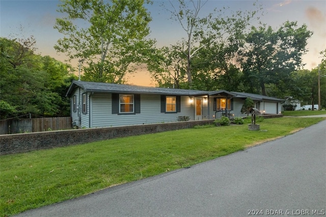 ranch-style home featuring a lawn and a garage