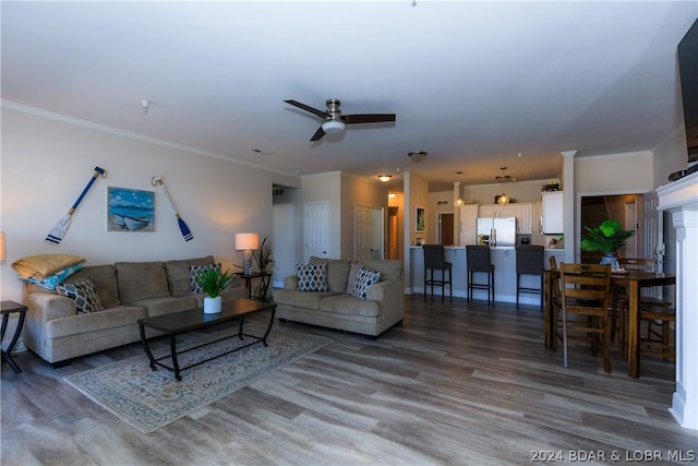 living room featuring hardwood / wood-style flooring, ceiling fan, and crown molding