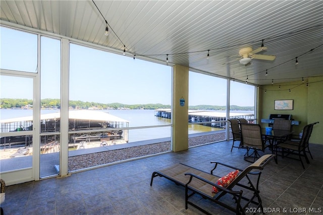 sunroom / solarium with a water view and ceiling fan