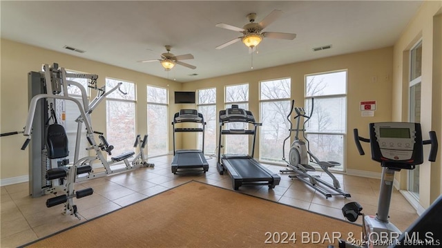 workout area featuring ceiling fan and light tile patterned floors