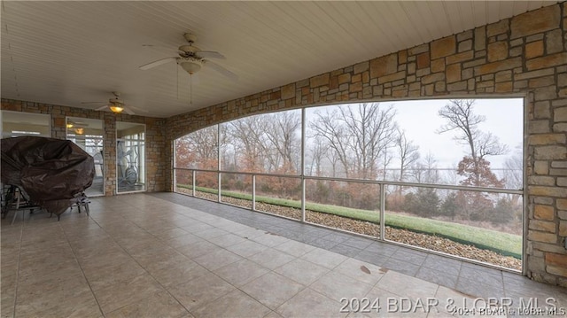 unfurnished sunroom featuring ceiling fan