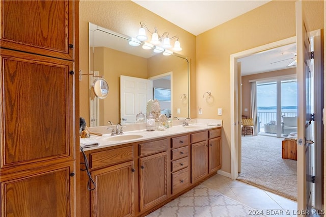 bathroom with a water view, vanity, and tile patterned floors