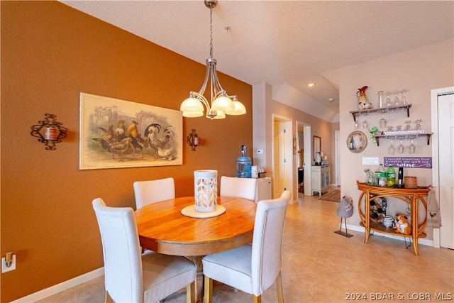 dining area featuring a notable chandelier, vaulted ceiling, and light tile patterned floors