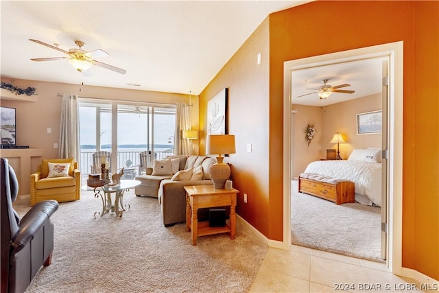 carpeted living room with a water view and ceiling fan