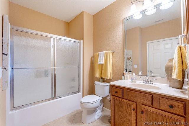 full bathroom featuring toilet, tile patterned flooring, combined bath / shower with glass door, and vanity