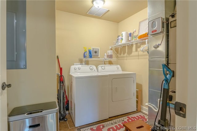 washroom with electric panel, independent washer and dryer, and light tile patterned floors