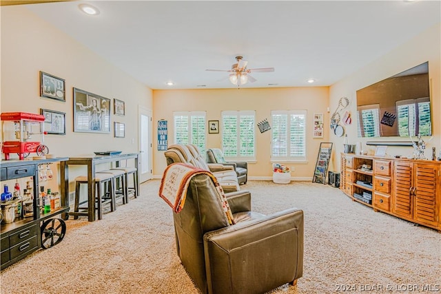 carpeted living room with ceiling fan and a healthy amount of sunlight