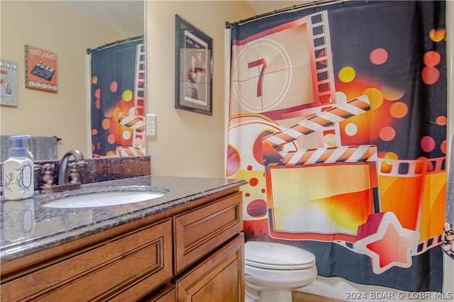 bathroom with curtained shower, vanity, and toilet