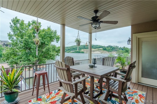 wooden terrace featuring ceiling fan and a water view