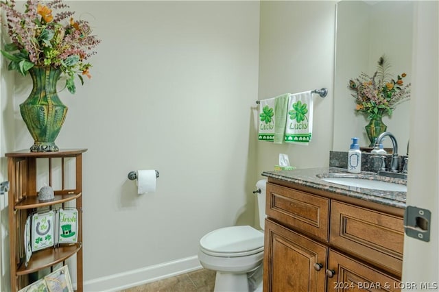 bathroom with tile patterned flooring, vanity, and toilet