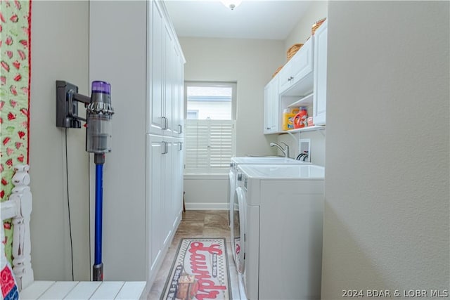 clothes washing area featuring cabinets and washing machine and clothes dryer