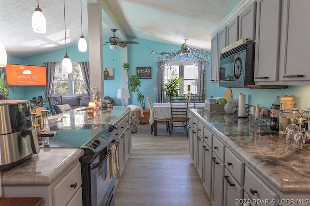 kitchen with black appliances, ceiling fan, a wealth of natural light, and lofted ceiling