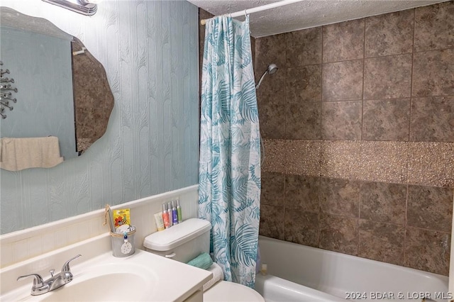 full bathroom featuring a textured ceiling, shower / bath combo, vanity, and toilet