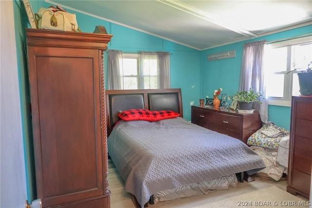 bedroom with lofted ceiling, multiple windows, and crown molding