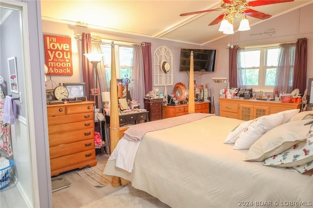 bedroom featuring ceiling fan, multiple windows, lofted ceiling, and hardwood / wood-style flooring