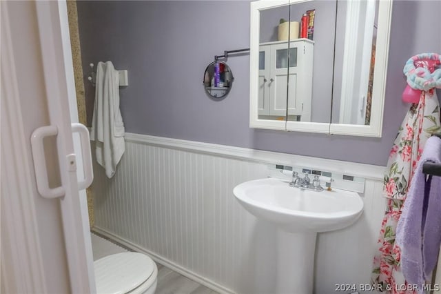 bathroom with toilet and wood-type flooring