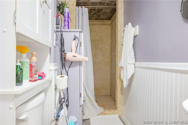 bathroom featuring toilet and a shower with curtain