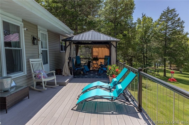 wooden deck featuring a yard and a gazebo