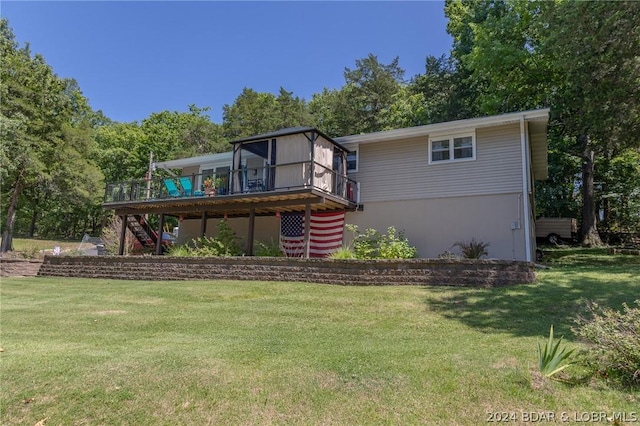 back of property featuring a wooden deck and a lawn