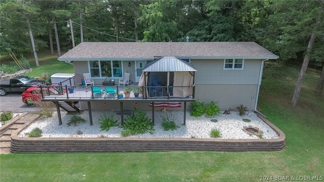 back of house with a deck and a yard