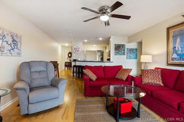 living room featuring light hardwood / wood-style floors and ceiling fan