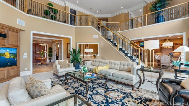 living room with a towering ceiling and ornamental molding