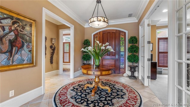 foyer entrance with light tile patterned flooring, ornamental molding, and french doors