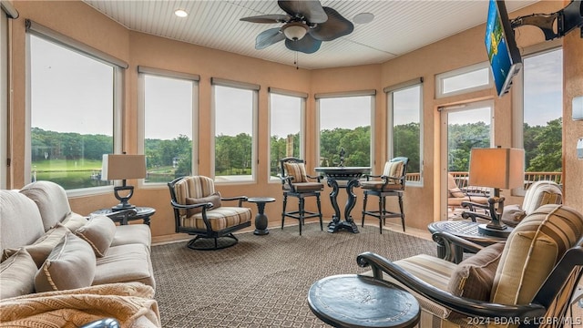 sunroom / solarium featuring ceiling fan