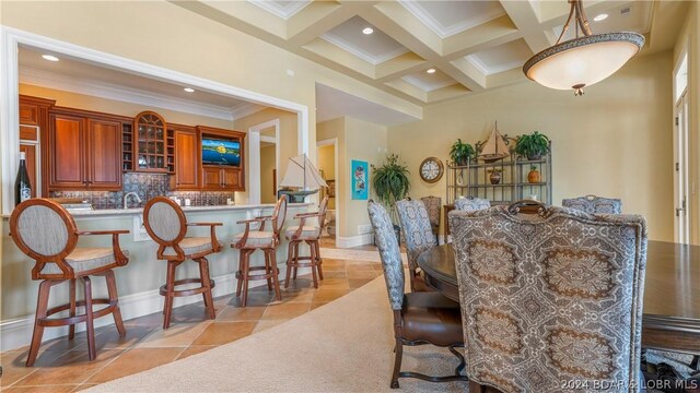 tiled dining space featuring crown molding, coffered ceiling, and beamed ceiling