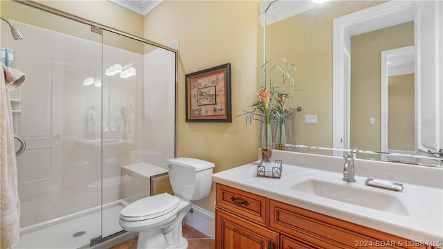 bathroom with toilet, vanity, a shower with door, and ornamental molding