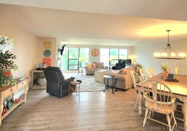 living room featuring hardwood / wood-style flooring, a textured ceiling, and a chandelier