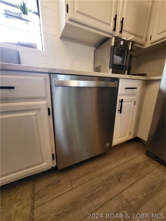 kitchen with white cabinets, stainless steel dishwasher, fridge, and light wood-type flooring