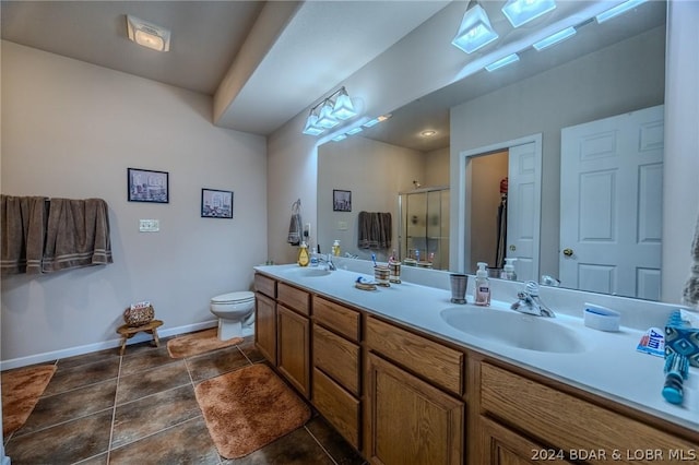 bathroom featuring a shower with door, vanity, and toilet