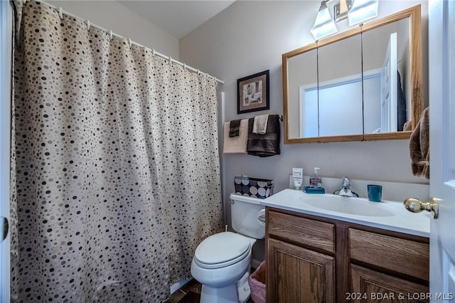 bathroom with curtained shower, vanity, and toilet